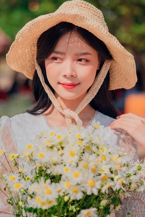 戴草帽手捧小雏菊的美女图片